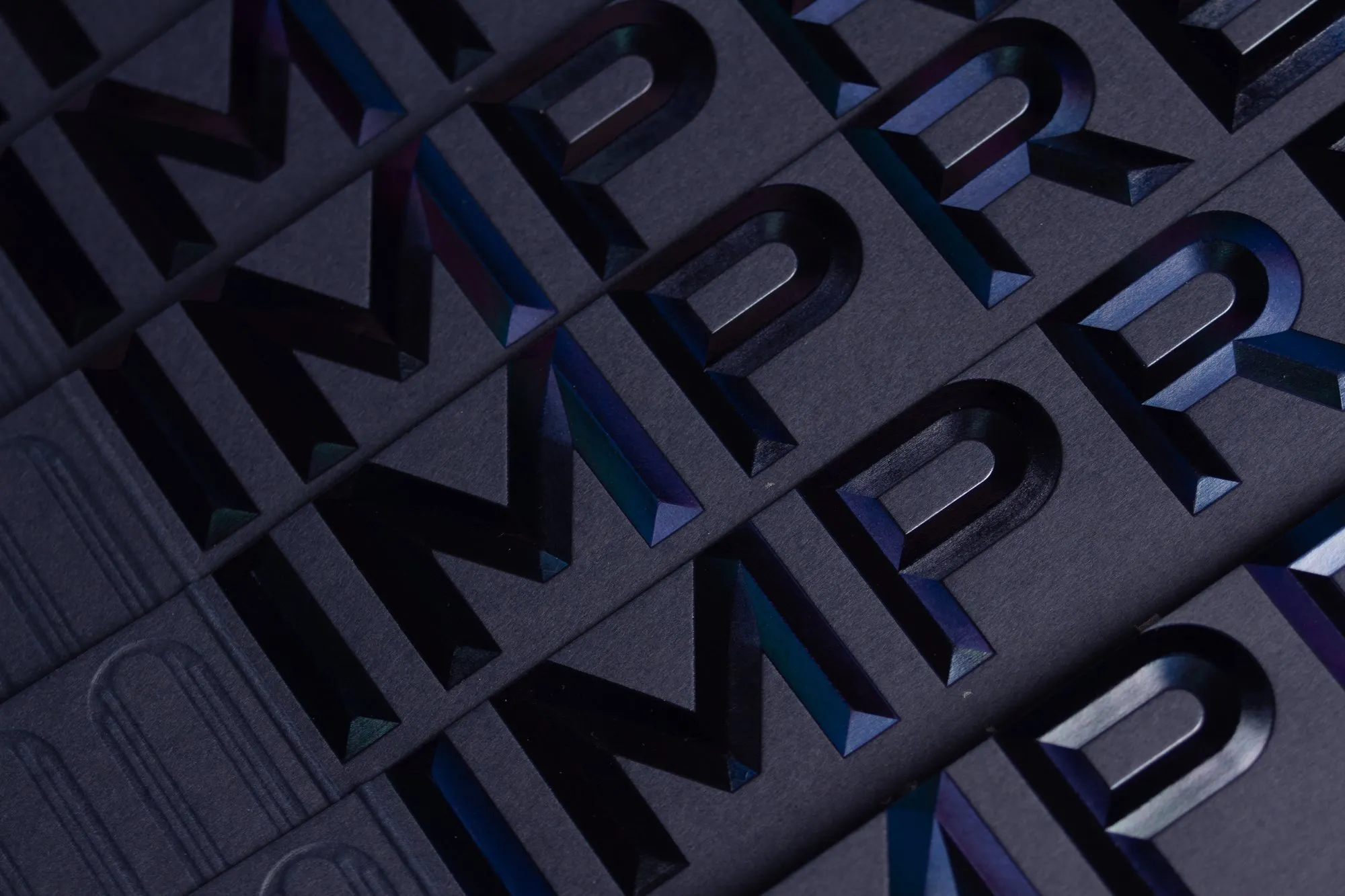 Iridescent foiled and debossed IMPRESSED lettering on navy card