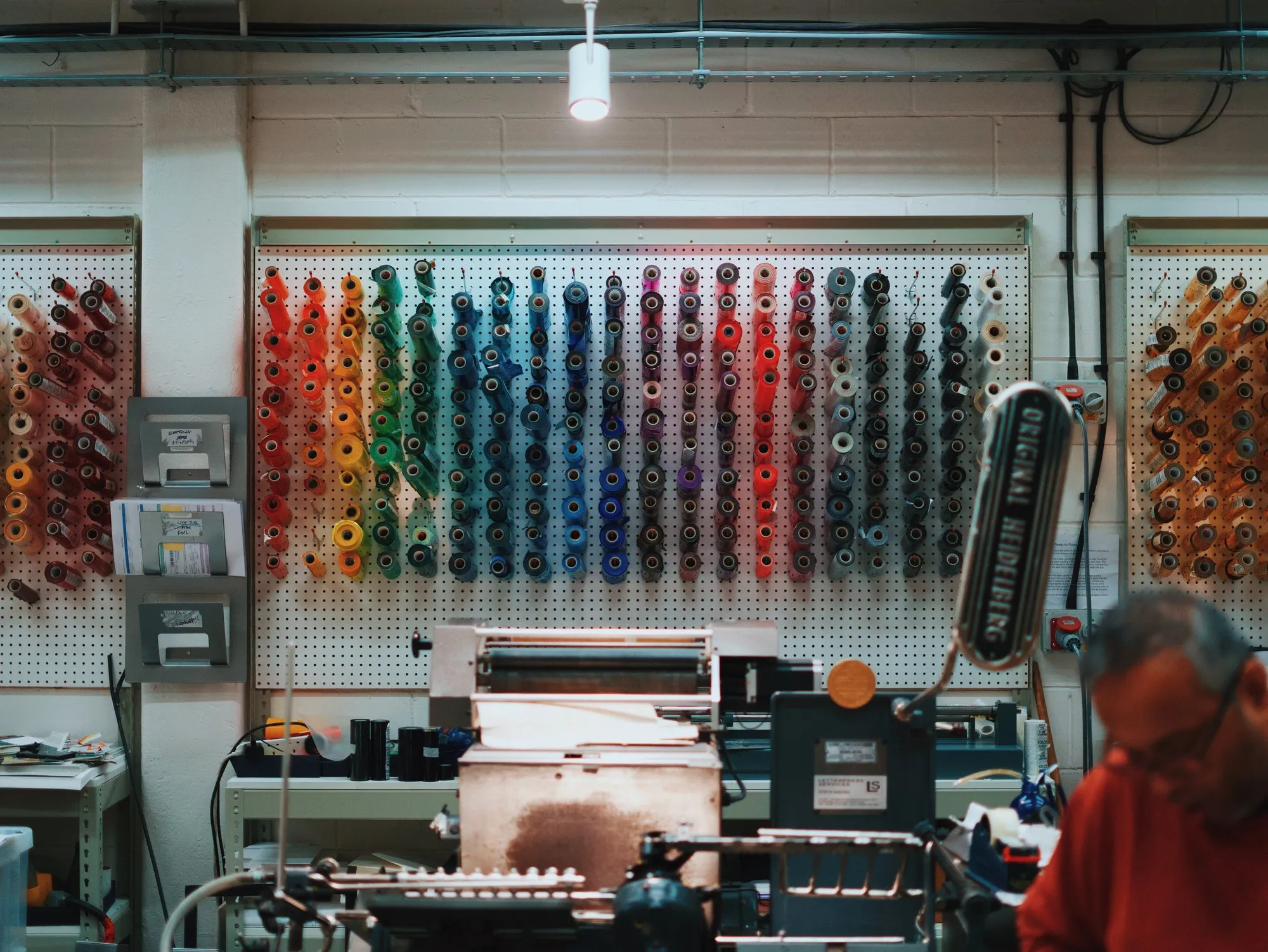 A wall of foil rolls in every colour above the presses in the Mount Street Printers workshop