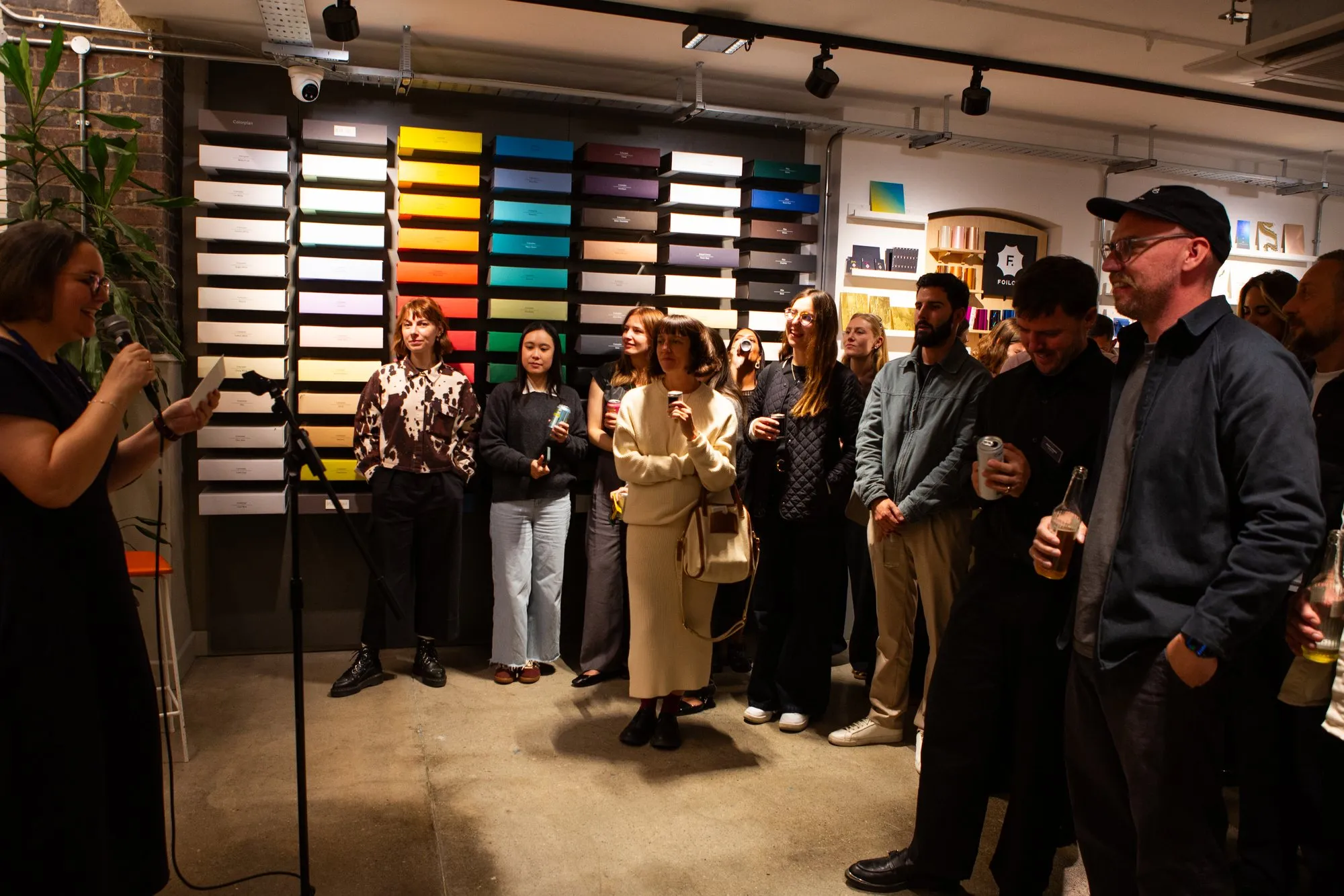 Guests gathered in front of a wall of coloured papers during a talk