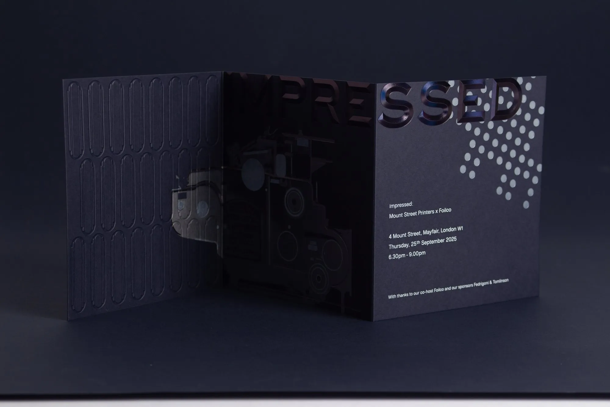 The Impressed invitation: navy card with iridescent foiled lettering and an embossed pattern