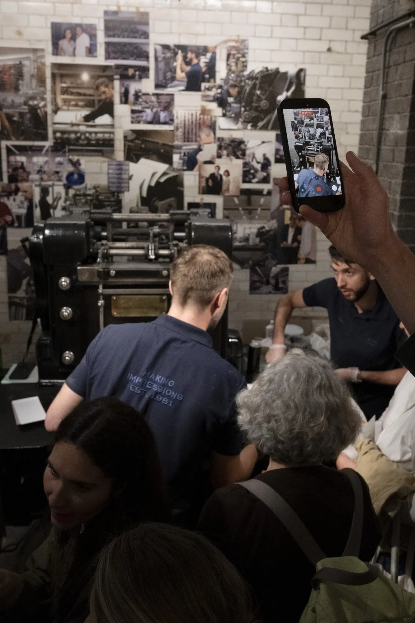 Guests filming a live die-stamping demonstration on the press