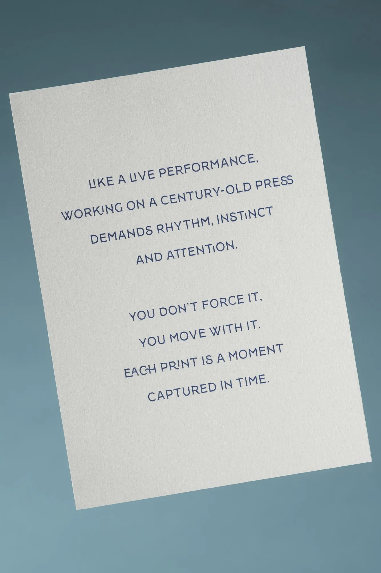 A printed card: "Like a live performance, working on a century-old press demands rhythm, instinct and attention."