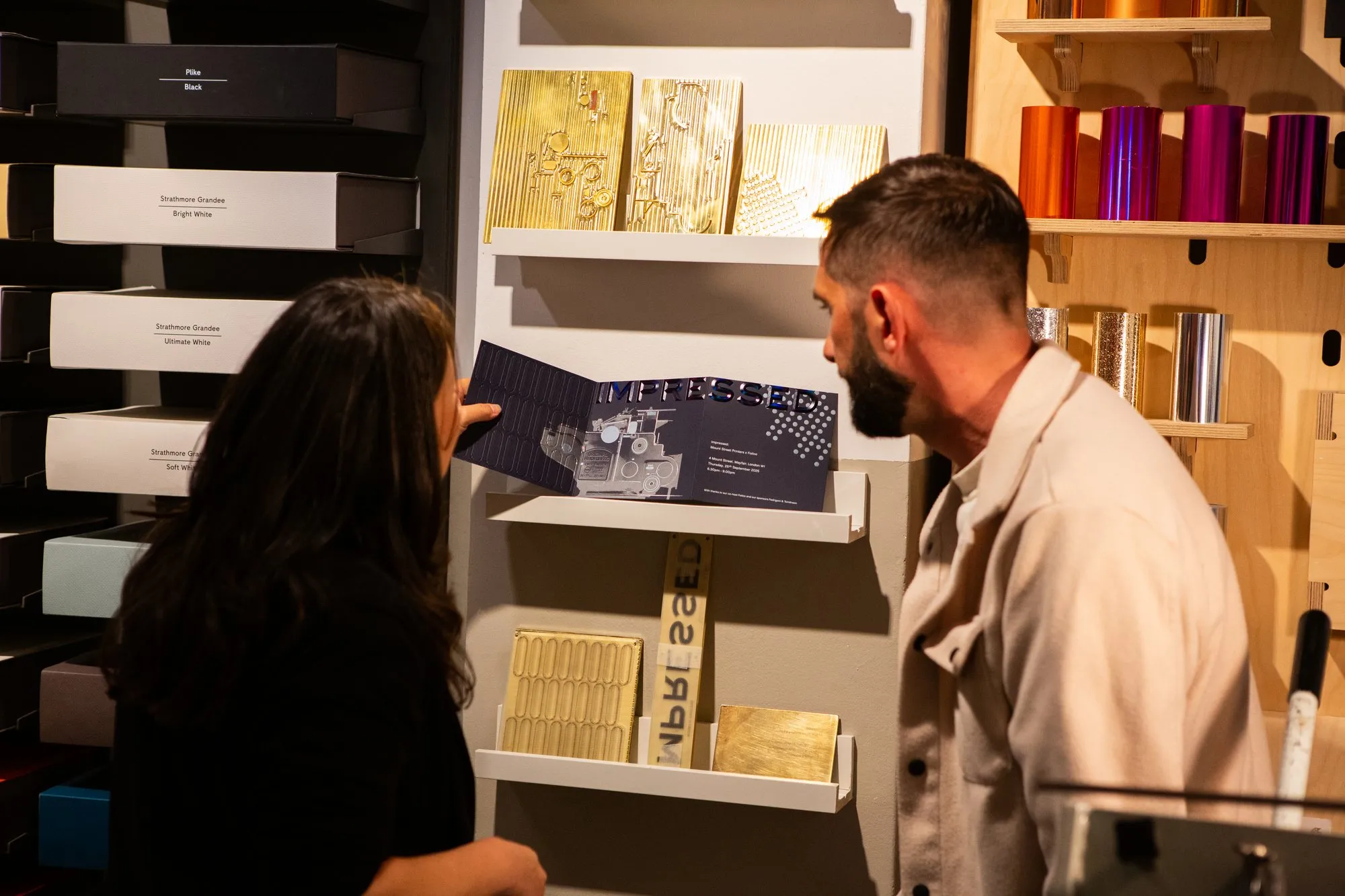 Guests looking at the invitation next to its brass dies at the event