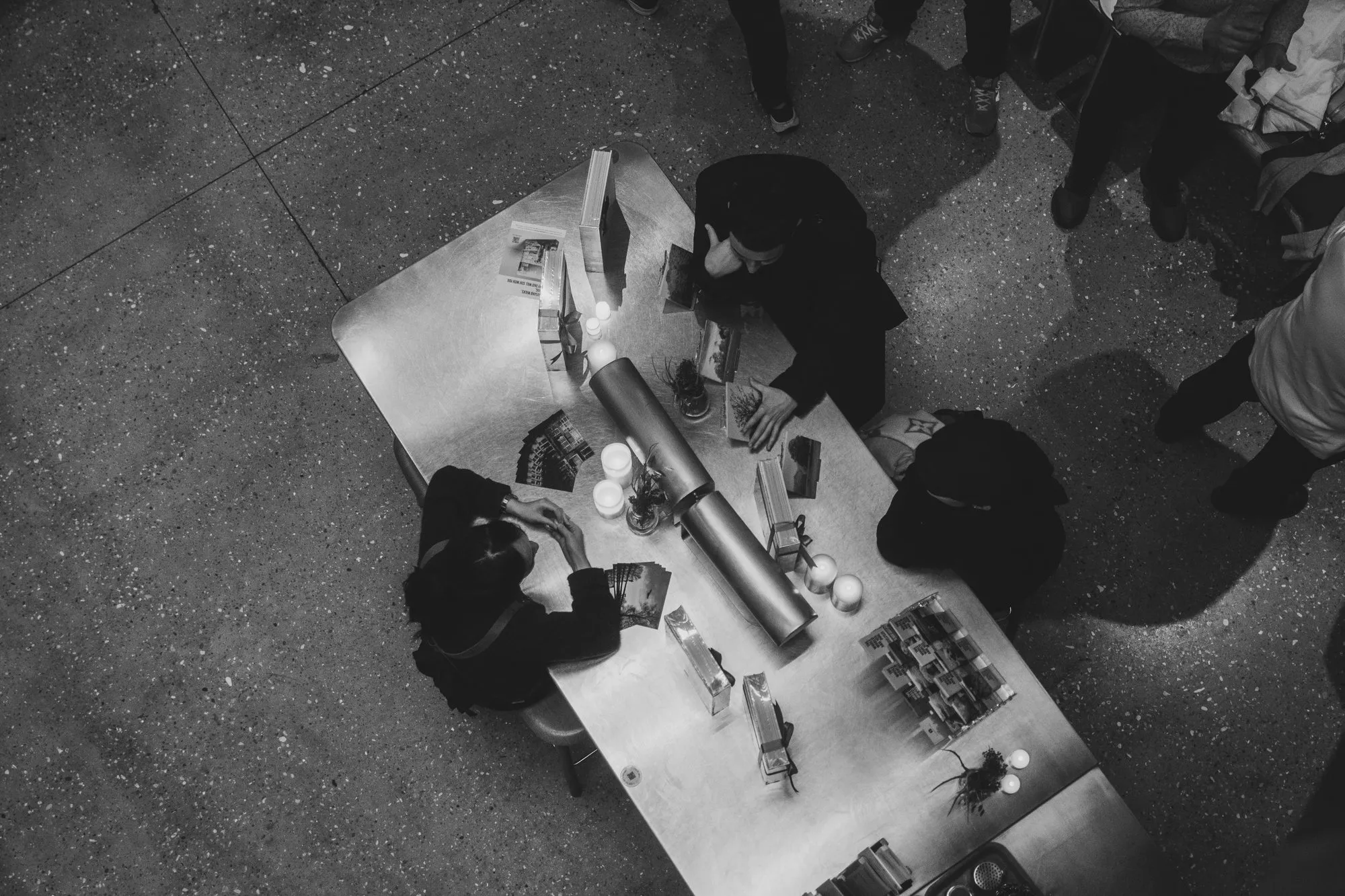 The book table from above, with candles and postcards